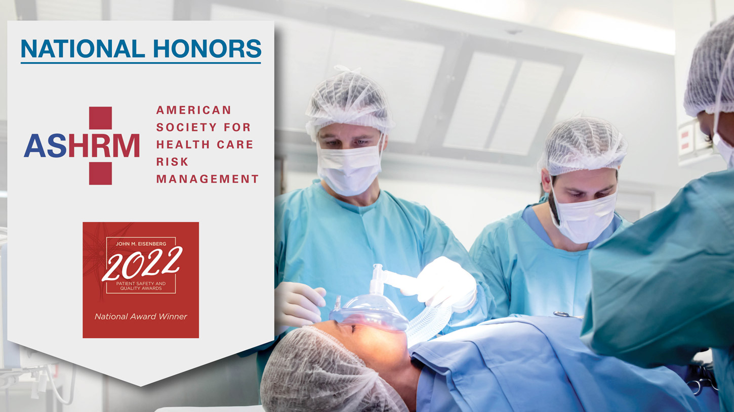 A group of surgeons performing an operation with an award for the american society for health care risk management (ashrm) 2022 national honors displayed in the foreground